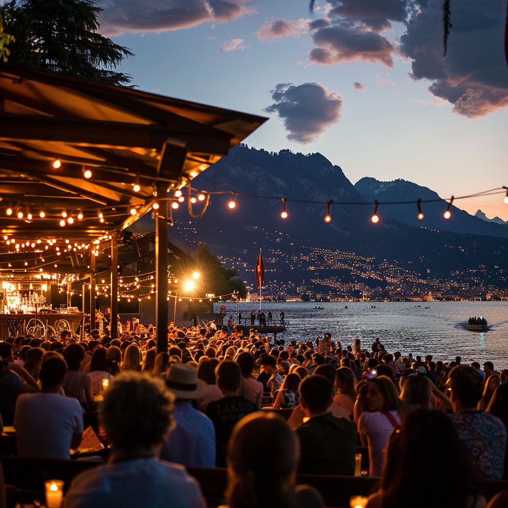 The Montreux Jazz Festival evening crowd with mountains and lake in the background, illuminated by string lights.