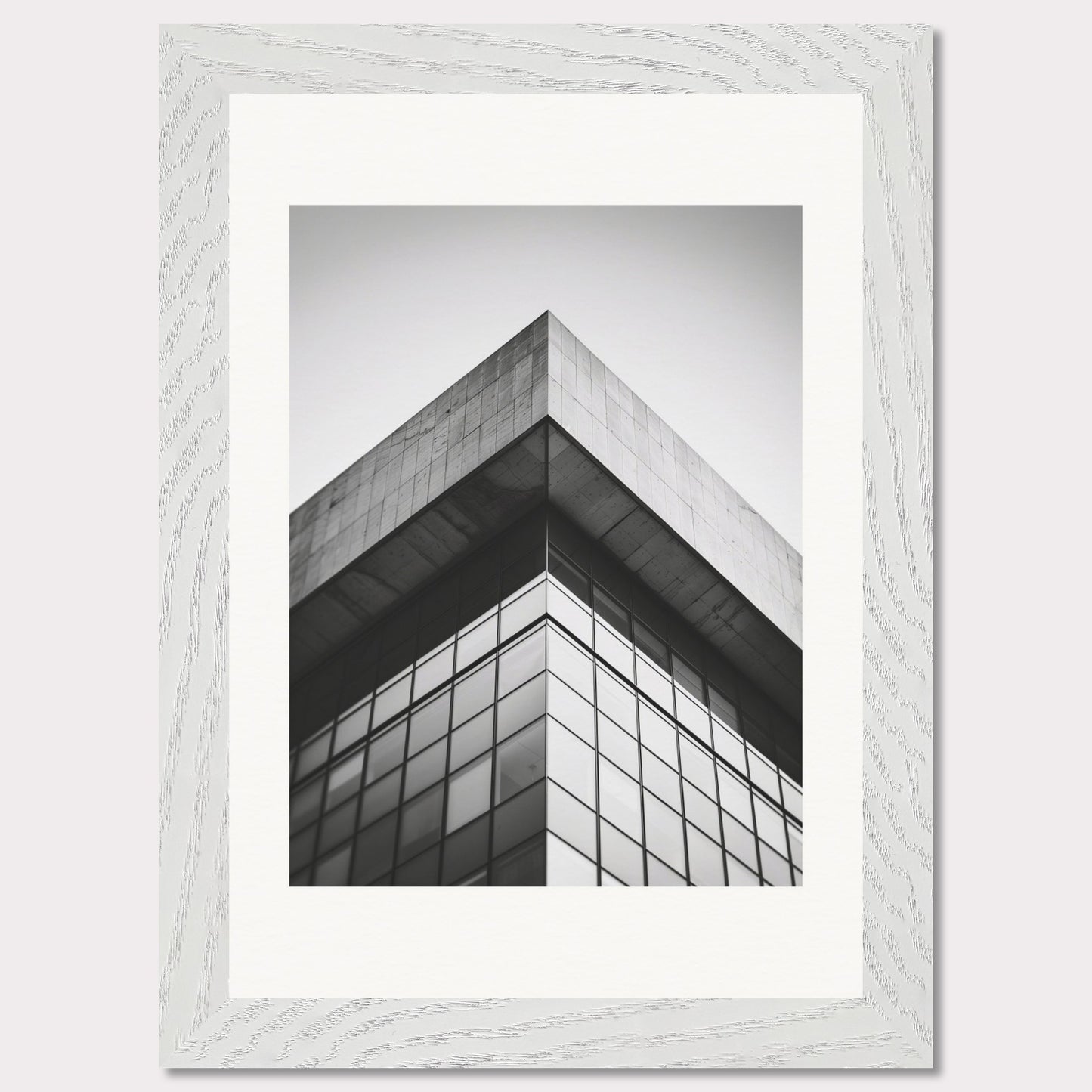 This striking black and white photograph captures the sharp, geometric lines of a modern architectural structure. The image focuses on the corner of a building, emphasizing its sleek glass windows and concrete elements.