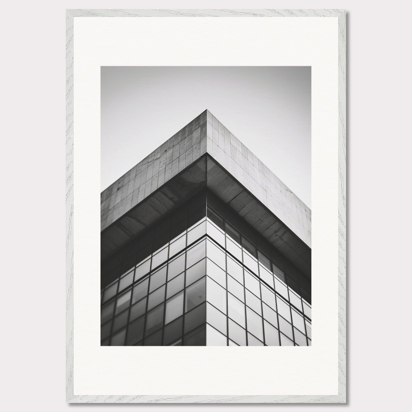 This striking black and white photograph captures the sharp, geometric lines of a modern architectural structure. The image focuses on the corner of a building, emphasizing its sleek glass windows and concrete elements.