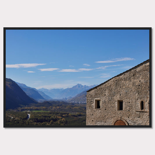 This stunning photograph captures a serene landscape with a historic stone building in the foreground and majestic mountains in the background.