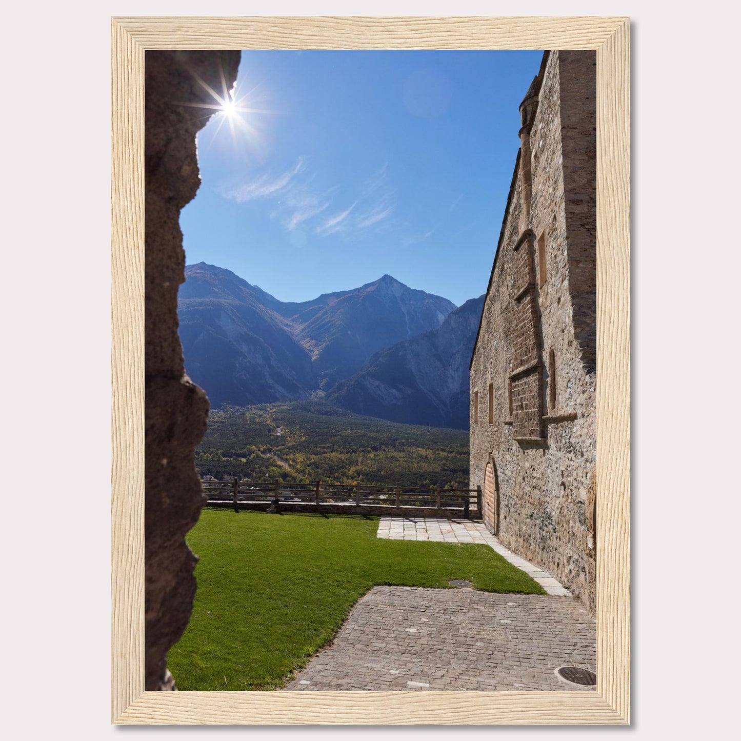 This captivating image showcases a stunning view of a mountainous landscape framed by the rustic stone walls of an ancient structure. The bright sun shines above, casting a warm glow over the scene.