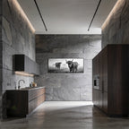 Alpine Cow Watch – Alu-Dibond wall art displayed in a modern kitchen with dark stone walls and sleek cabinets.