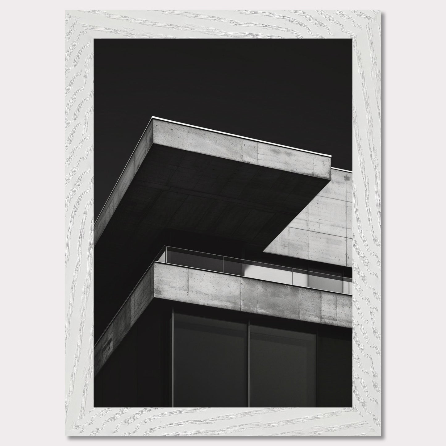 This striking black and white photograph captures the modern architectural lines of a concrete building against a dark background. The image highlights the stark contrast and geometric precision of contemporary design.