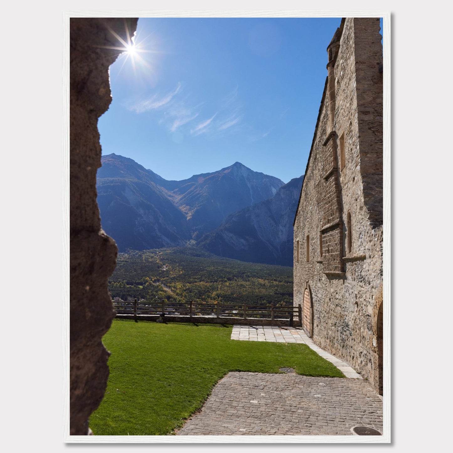 This captivating image showcases a stunning view of a mountainous landscape framed by the rustic stone walls of an ancient structure. The bright sun shines above, casting a warm glow over the scene.