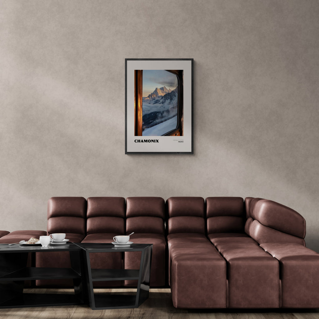 Chamonix - A Window to the Wild - Poster framed on wall above modern brown couch in stylish living room.