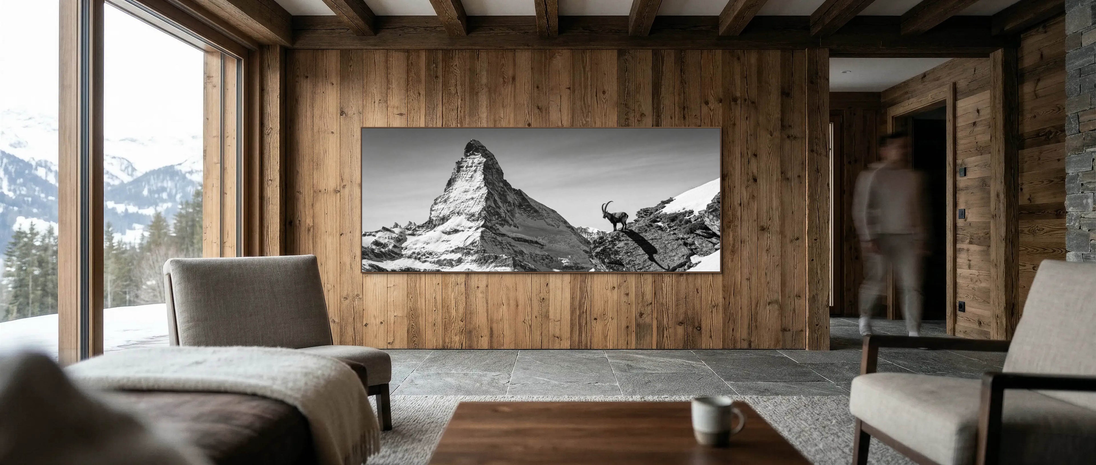 Living room with a large TV displaying a mountain landscape, wooden walls, and furniture.