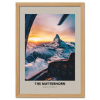 Aerial view of The Matterhorn at sunrise from a cockpit, showcasing snowy peaks and warm golden light.