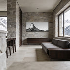 Matterhorn with Birds – Alu-Dibond wall art displayed in a modern living room with stone walls.