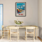 Sunny Ski Alps Escape - Poster displayed in a modern dining area with wooden chairs and a flower centerpiece.